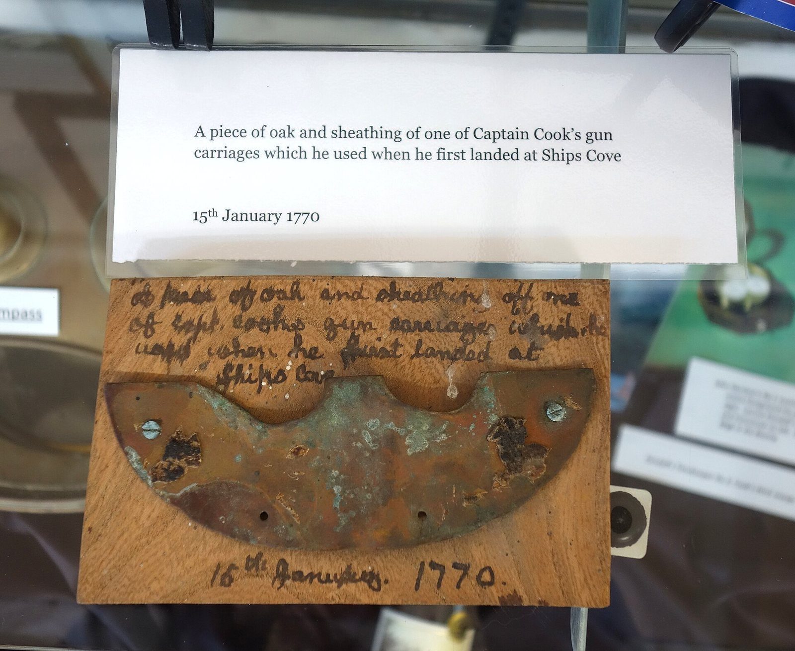 A fragment of oak and copper sheathing displayed in a museum case
