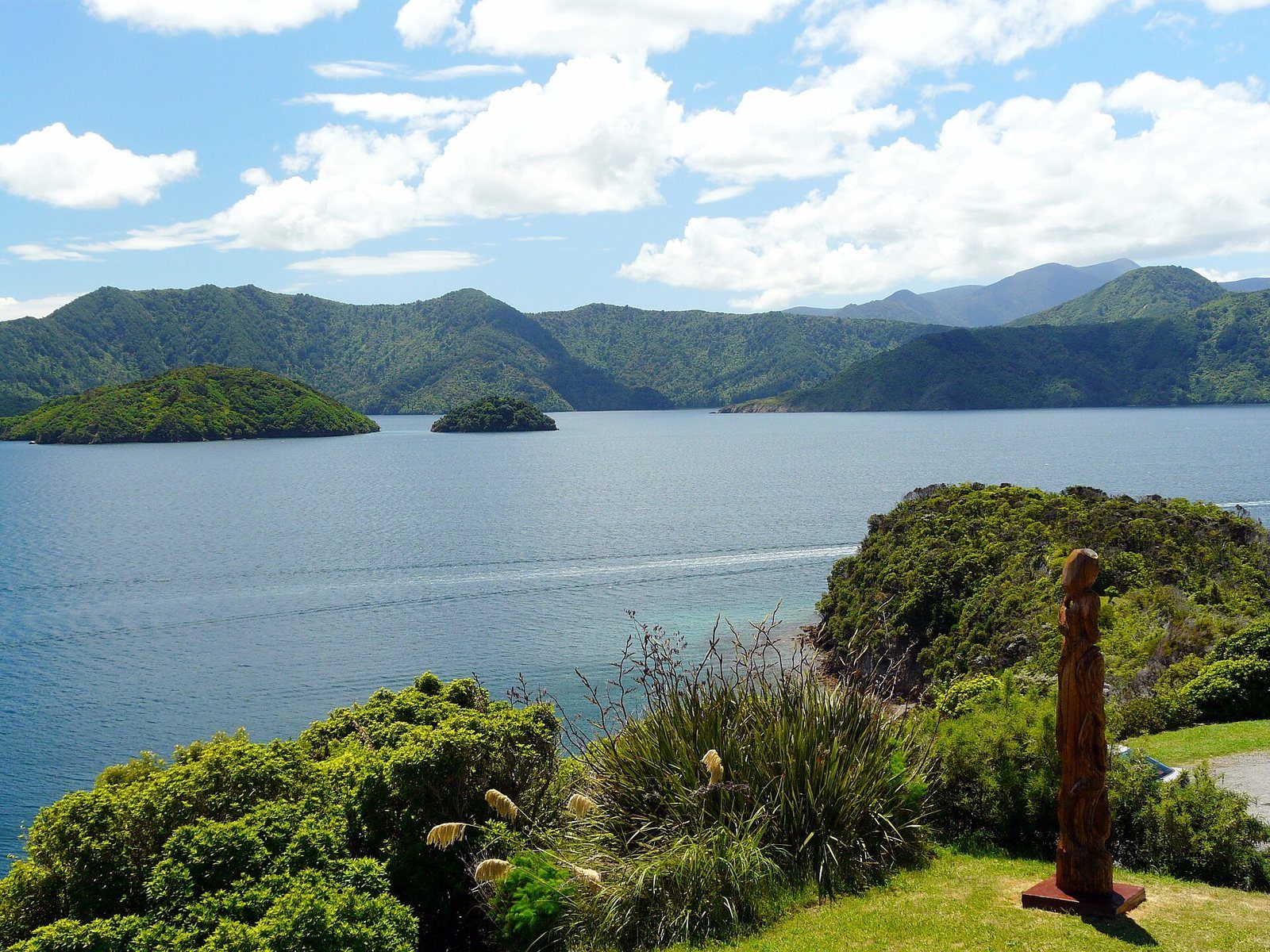 A carved pou and the view over the sound from Karaka Point