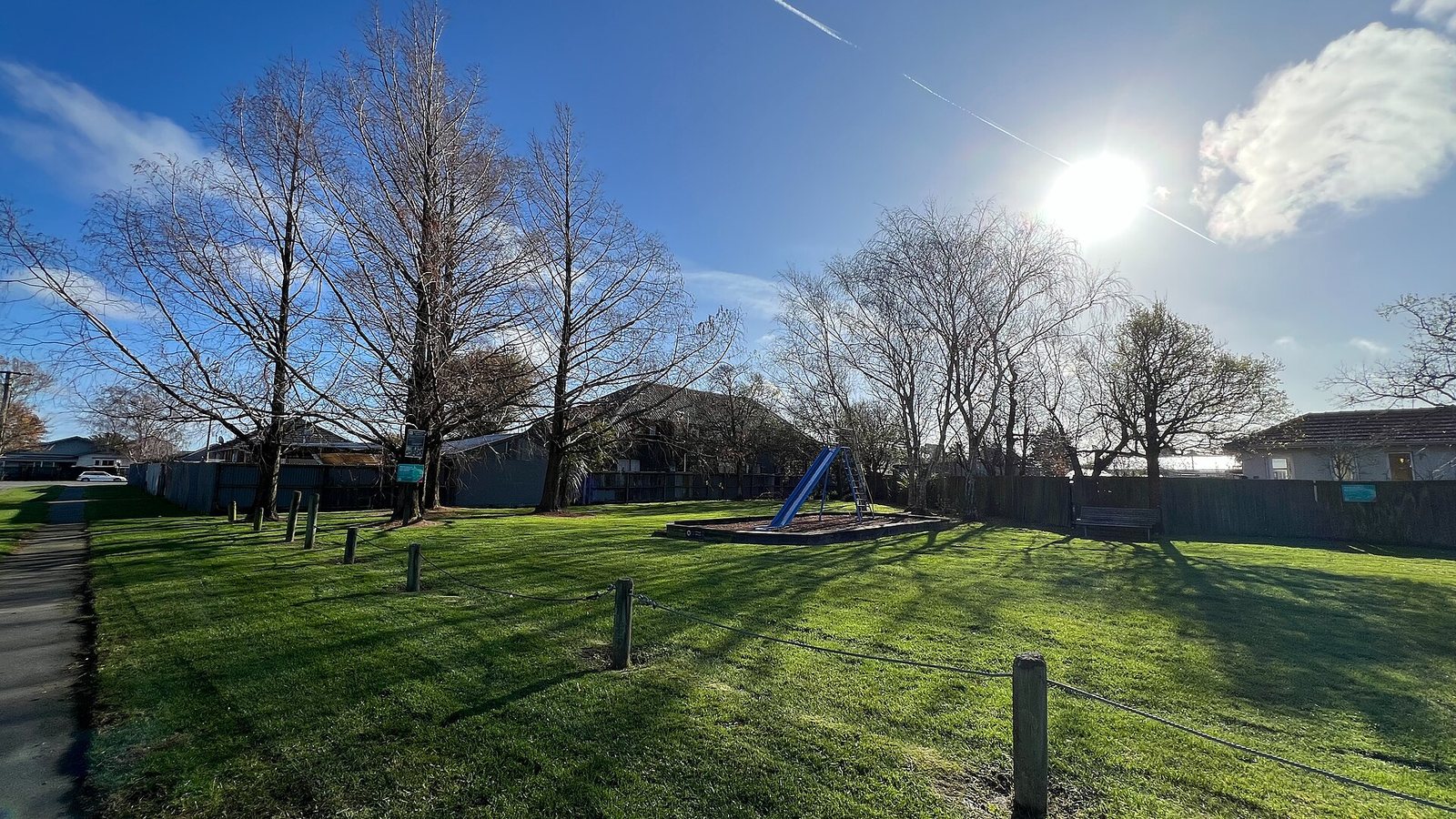 A small playground with swings and a slide on grass at Momorangi Bay