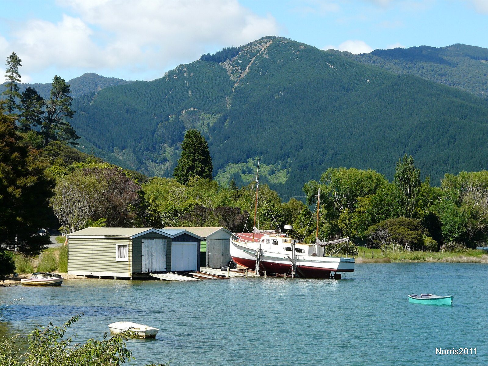 Old timber boathouses on the shore at Okiwa Bay