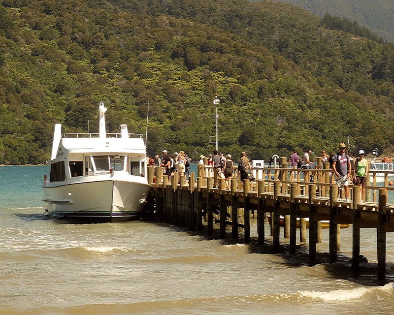 Visitors and a passenger boat at Anakiwa jetty, a transport point at the southern end of the Queen Charlotte Track.