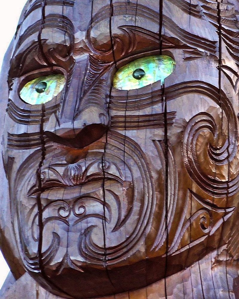 Close view of the carved face of Kupe on the pouwhenua at Meretoto / Ship Cove.