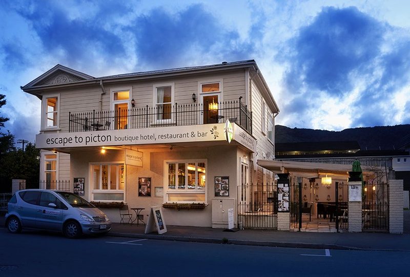 Street view of Escape to Picton's historic two-storey facade, entrance and courtyard at dusk.