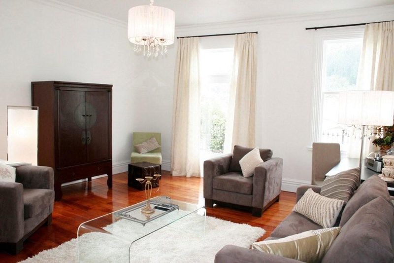 Modern Suite lounge with upholstered seating, glass coffee table and polished timber floor.