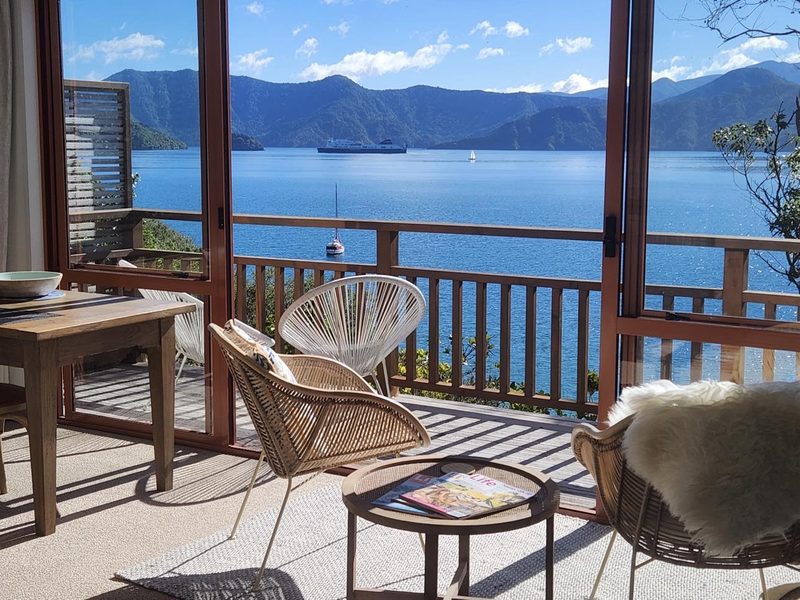 Queen Charlotte Sound and passing ferry seen through Seascape Cottage's open deck doors.