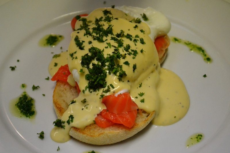 Eggs Benedict with smoked salmon, hollandaise and chopped herbs on toasted bread.