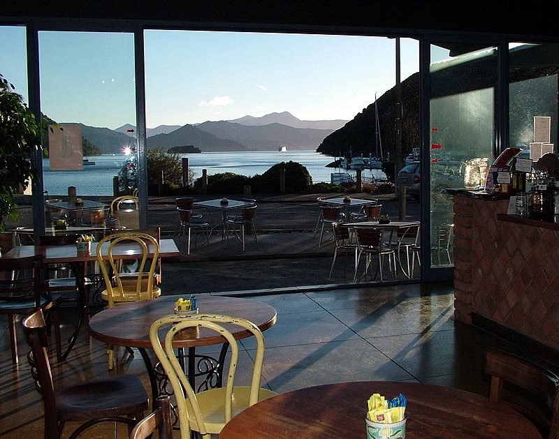 Le Café dining room and terrace looking through large windows over Picton Harbour and the surrounding hills.