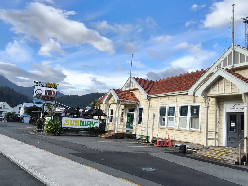 Subway Picton entrance and signage on the cream railway station building, with outdoor seating beside it.