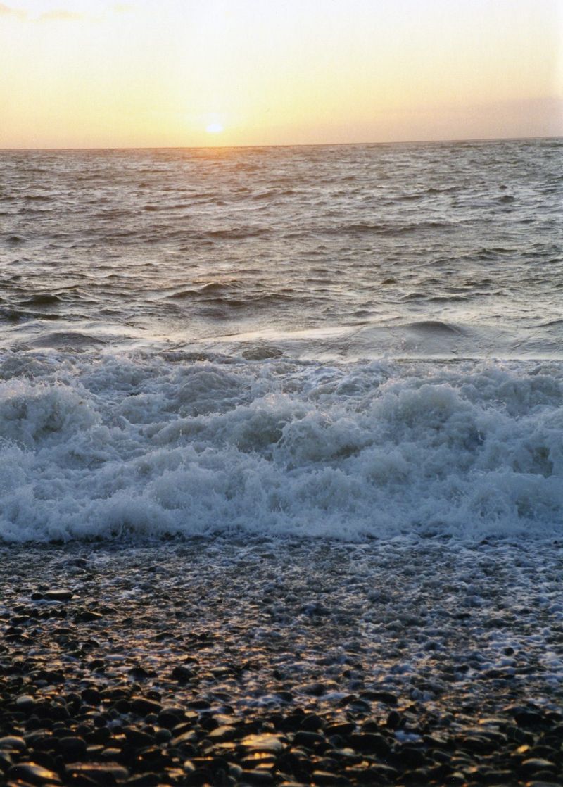Small waves breaking on a shingle shore at sunset