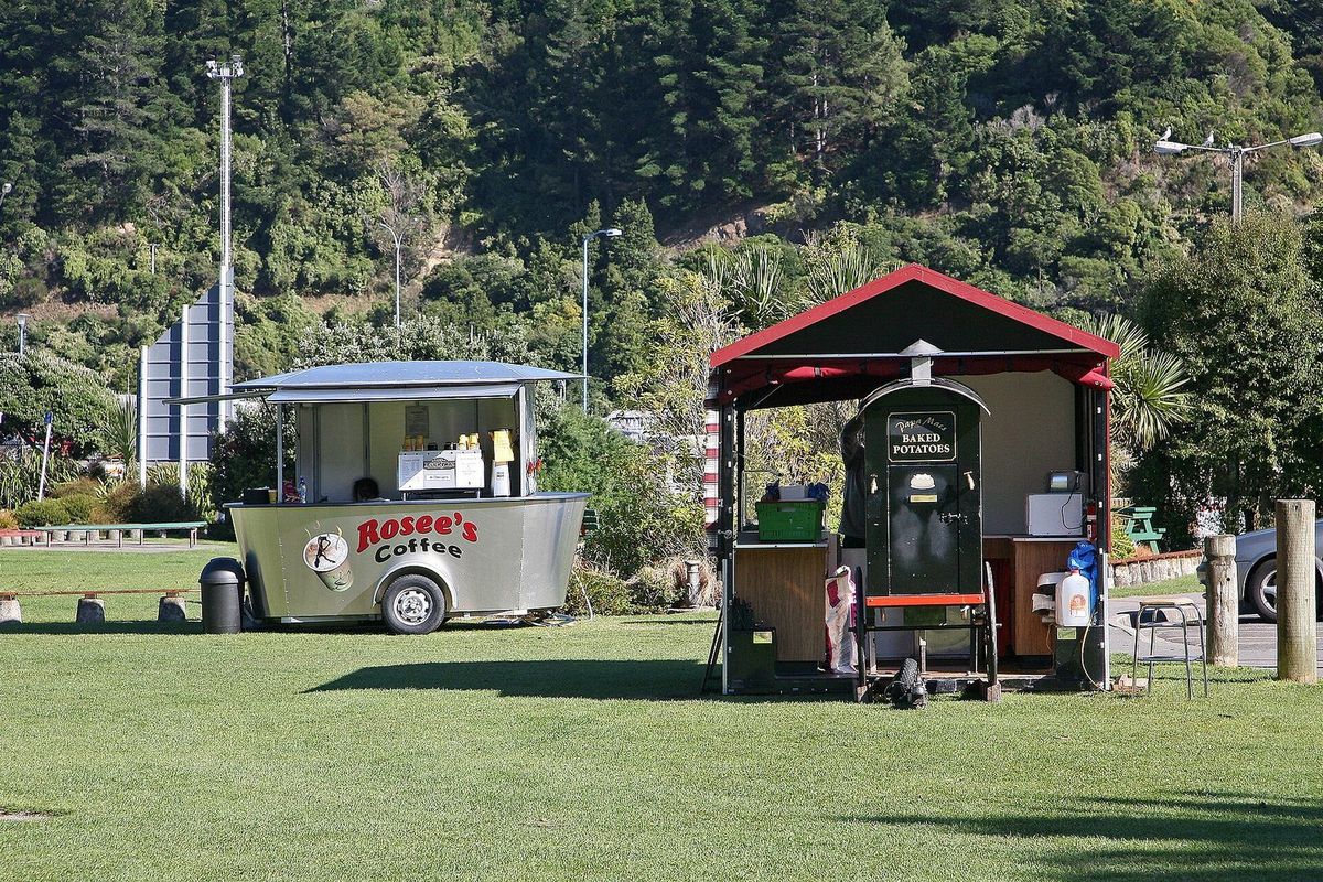 Two small food and coffee carts parked on the grass of the Picton foreshore