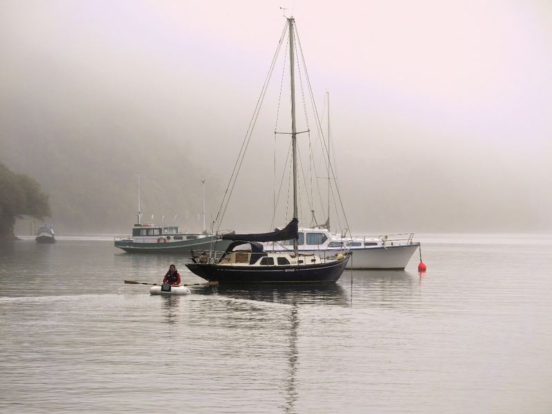 Moored yachts and boats in mist on still water