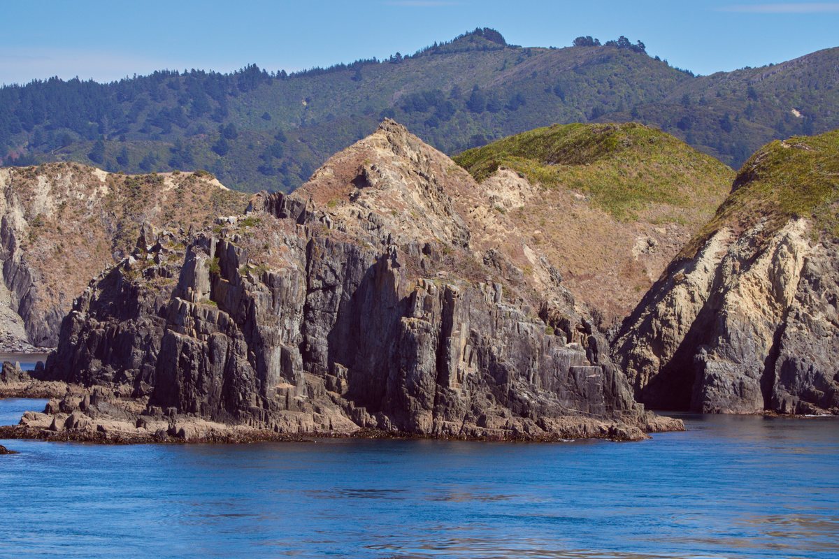 Clear blue sky over the rocky coastline of Queen Charlotte Sound on a still Marlborough day